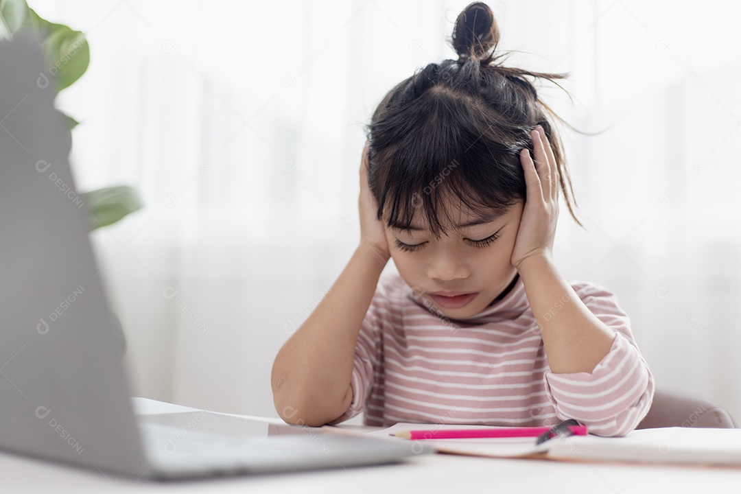 Menina asiática sentada sozinha e olhando com um rosto entediado, criança pré-escolar deitada de cabeça na mesa com triste entediado com lição de casa, criança mimada