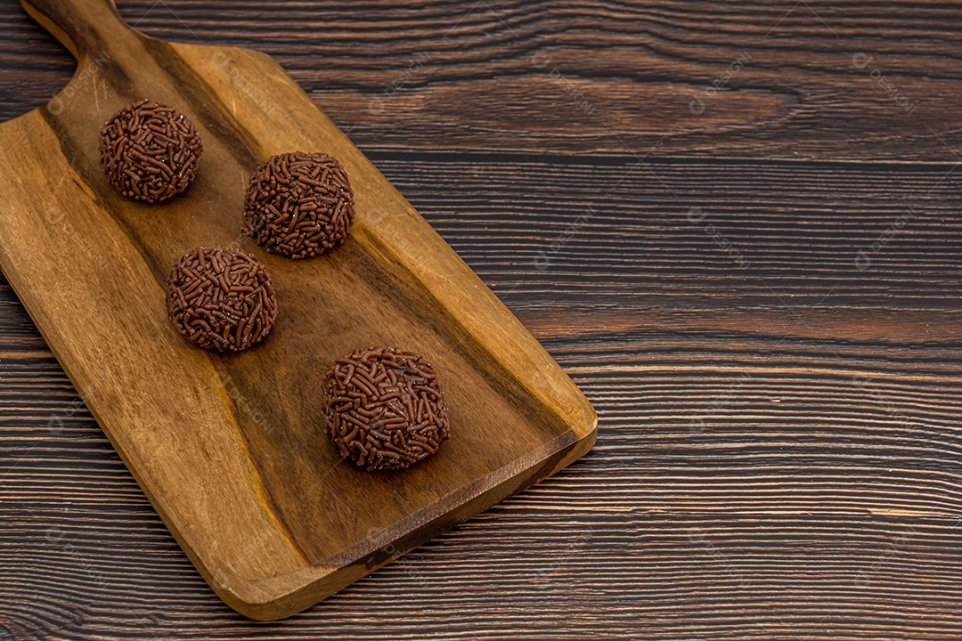 Brigadeiro brasileiro tradicional deliciosa sobremesa de chocolate, lanches de festa, vista superior de fundo polvilhado doce sobre a mesa de madeira