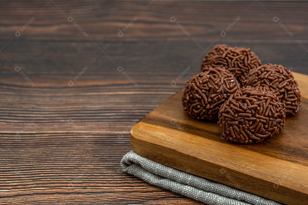 Brigadeiro brasileiro tradicional deliciosa sobremesa de chocolate, lanches de festa, vista superior de fundo polvilhado doce sobre a mesa de madeira