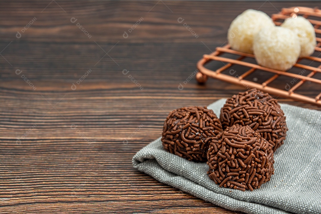 Brigadeiro brasileiro tradicional deliciosa sobremesa de chocolate, lanches de festa, vista superior de fundo polvilhado doce sobre a mesa de madeira