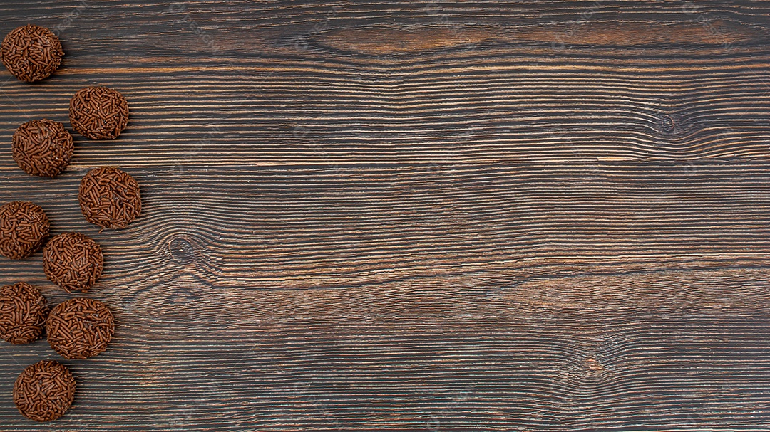 Brigadeiro brasileiro tradicional deliciosa sobremesa de chocolate, lanches de festa, vista superior de fundo polvilhado doce sobre a mesa de madeira