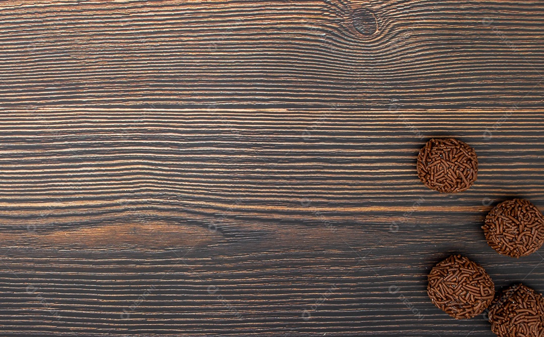 Brigadeiro brasileiro tradicional deliciosa sobremesa de chocolate, lanches de festa, vista superior de fundo polvilhado doce sobre a mesa de madeira
