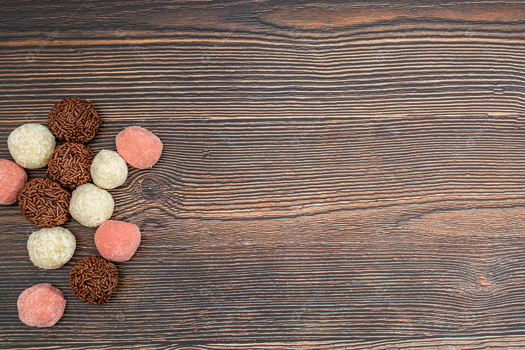brigadeiro brasileiro, beijinho e bicho de pé, tradicional deliciosa sobremesa de chocolate, petiscos de festa, fundo de polvilho doce vista superior sobre a mesa de madeira