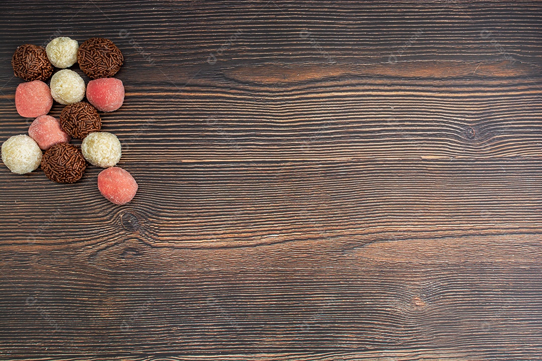 brigadeiro brasileiro, beijinho e bicho de pé, tradicional deliciosa sobremesa de chocolate, petiscos de festa, fundo de polvilho doce vista superior sobre a mesa de madeira