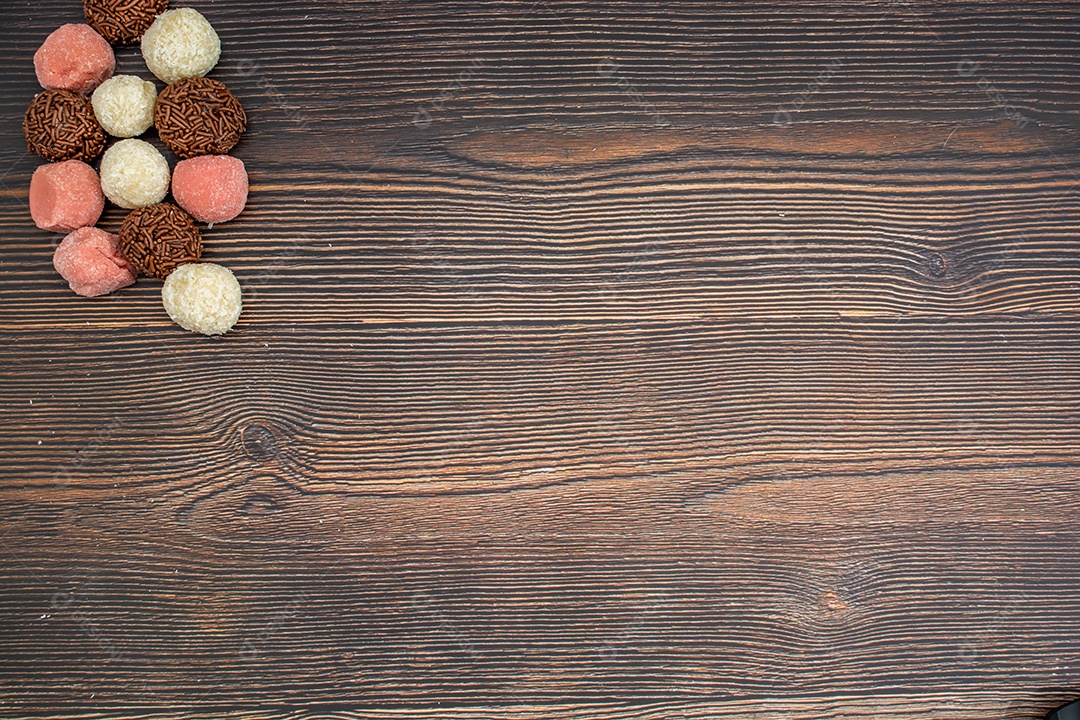 brigadeiro brasileiro, beijinho e bicho de pé, tradicional deliciosa sobremesa de chocolate, petiscos de festa, fundo de polvilho doce vista superior sobre a mesa de madeira