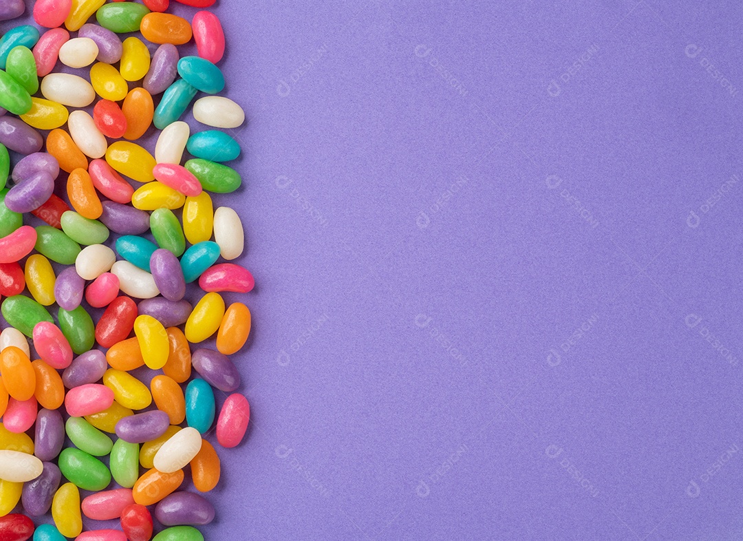 Jujubas coloridas sobre fundo roxo com espaço de cópia.