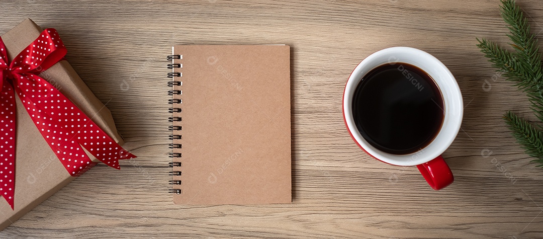 Caderno em branco, xícara de café preto e presente de Natal na mesa de madeira