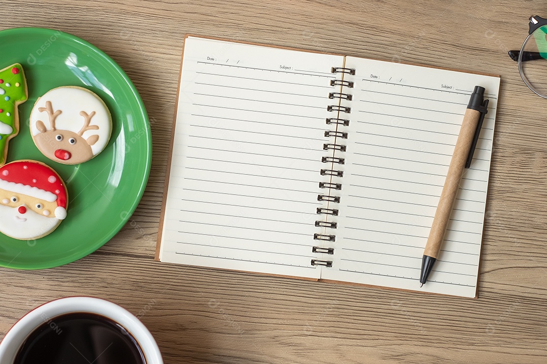 Caderno em branco, xícara de café preto, biscoitos de Natal e caneta