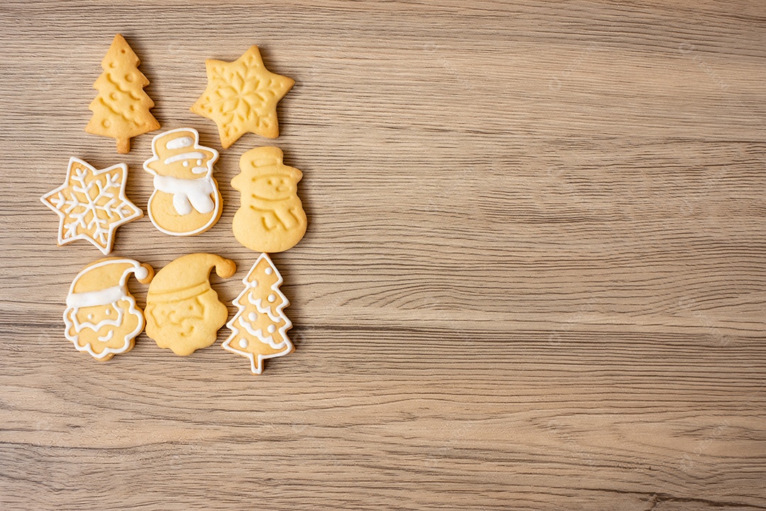 Feliz Natal com biscoitos caseiros no fundo da mesa de madeira.