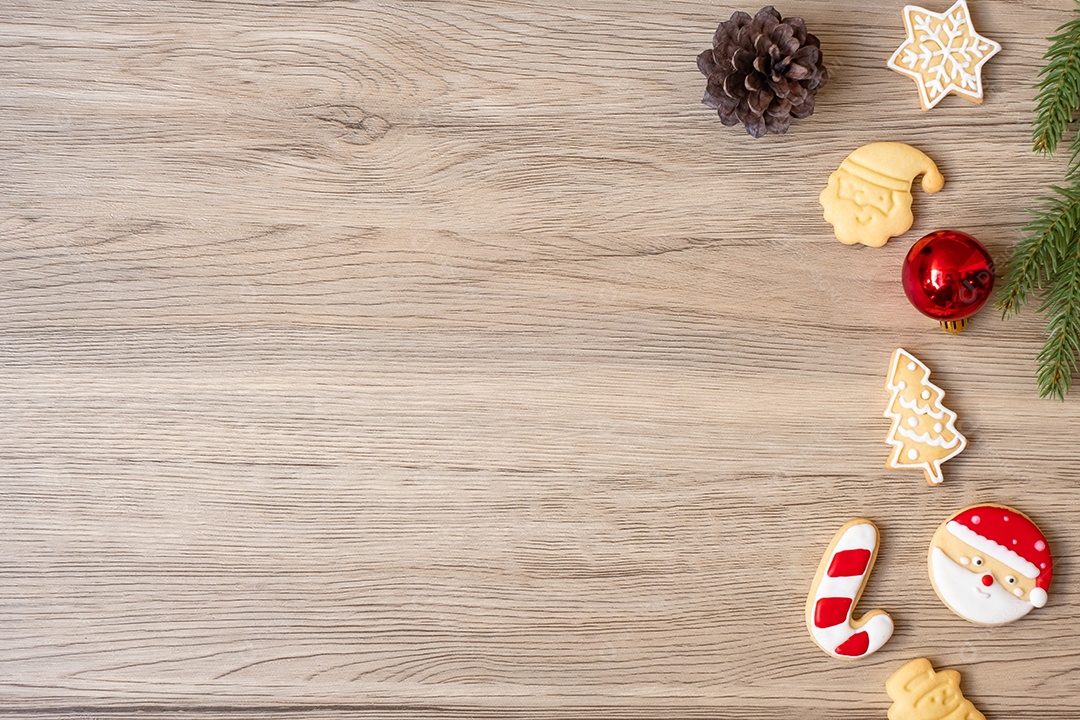 Feliz Natal com biscoitos caseiros no fundo da mesa de madeira.