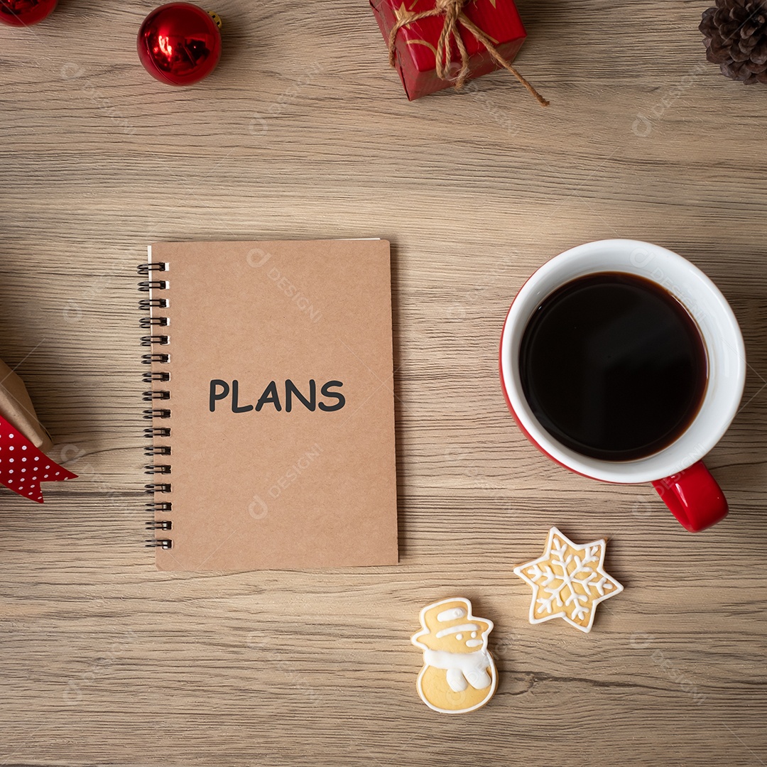 Caderno, xícara de café preto, biscoitos de natal e caneta na madeira