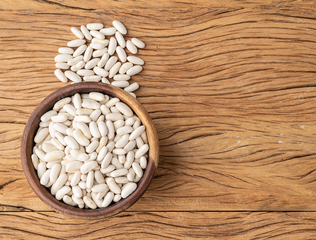 Feijão branco em uma tigela sobre a mesa de madeira
