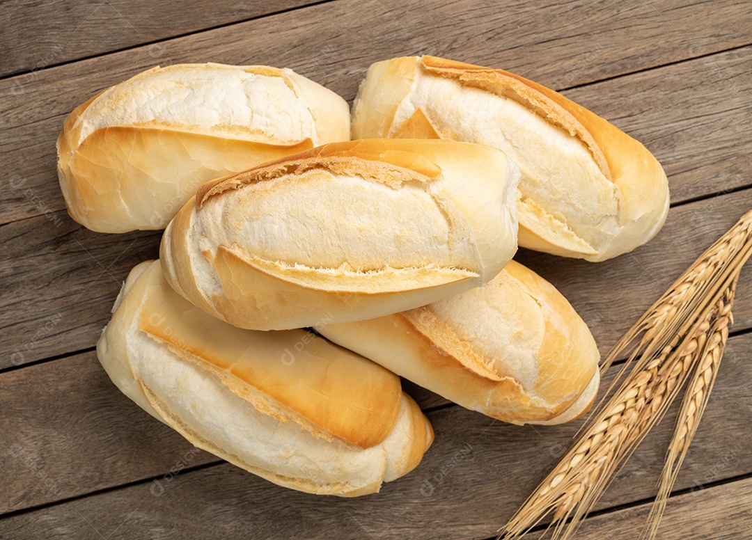 Pão francês, pão de sal ou pistolet sobre a mesa de madeira.