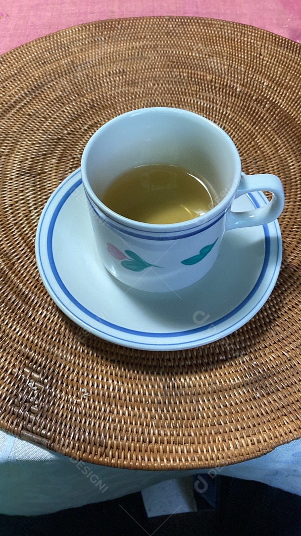 Xicara de bebida sobre uma mesa de vidro.