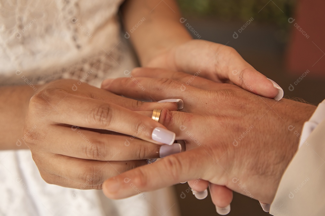Noiva colocando aliança e mãos de seu esposo