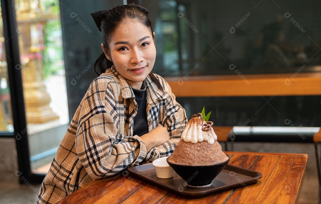 Mulher coreana sentada em lanchonete comendo sobremesa gelada - bingsu do chocolate