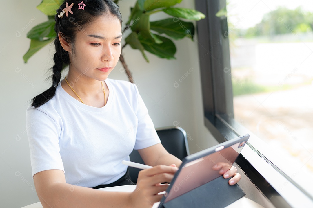 Mulher asiática sentada segurando um tablet