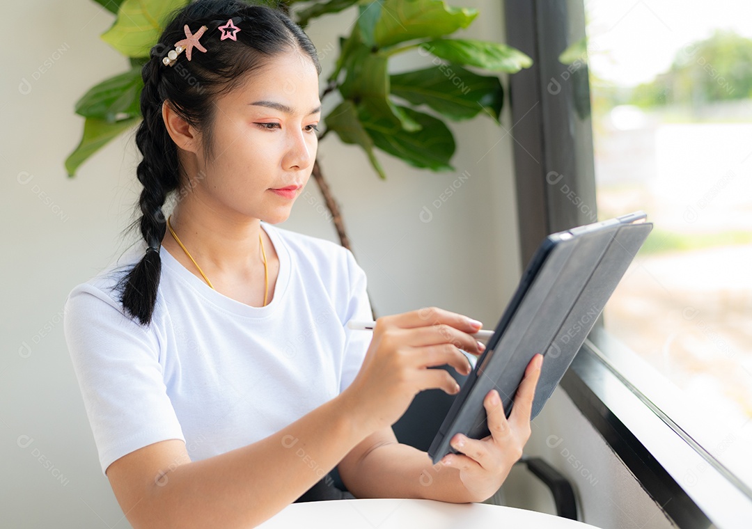 Mulher asiática sentada segurando um tablet