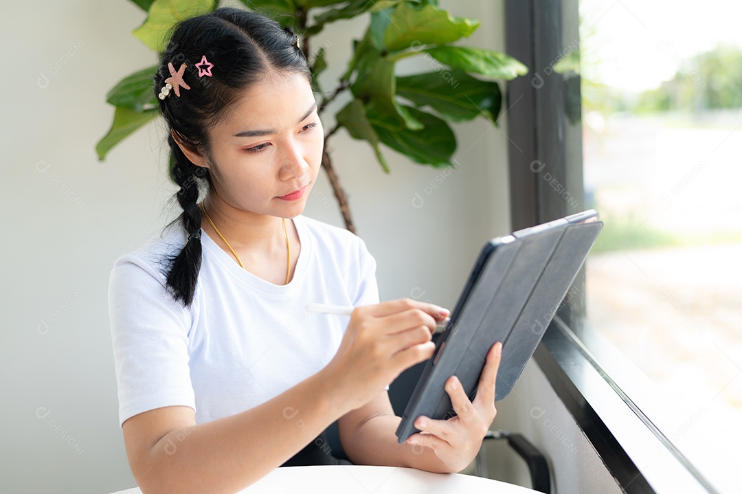 Mulher asiática sentada segurando um tablet