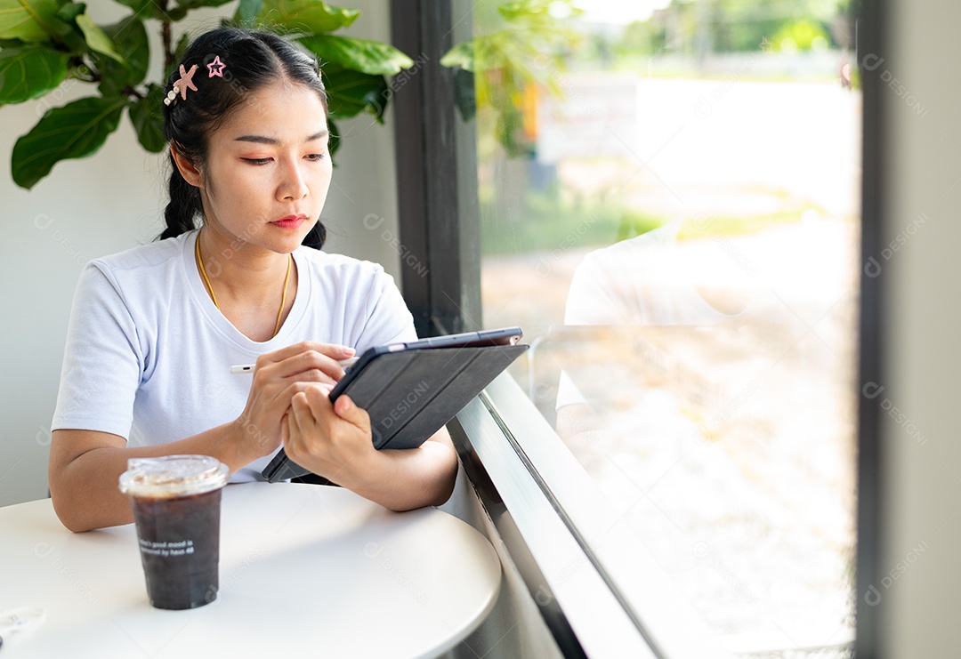 Mulher asiática sentada segurando um tablet