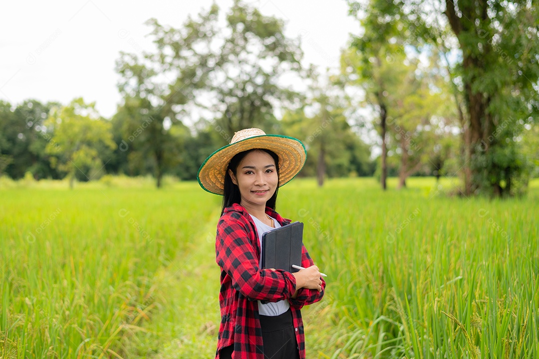 Mulher agricultora segurando um tablet e fazendo analise das plantações