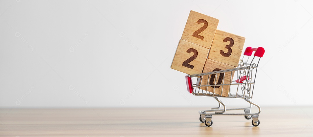 Feliz ano novo com bloco de 2023 no carrinho de compras na mesa