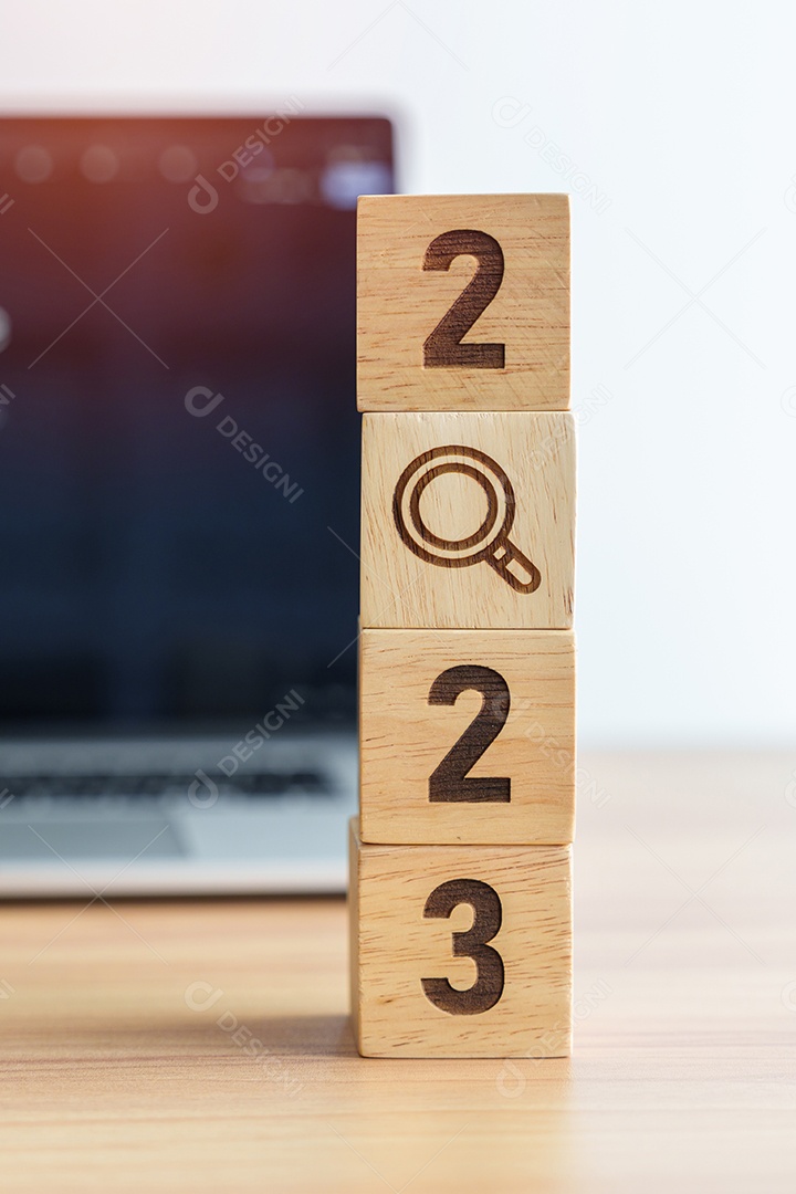 Bloco de 2023 com ícone de lupa contra o fundo do laptop.