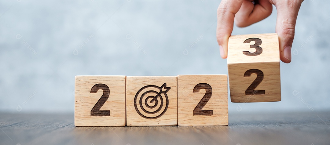 Virar a mão 2022 para 2023 bloco com placa de dardos. Meta de negócios