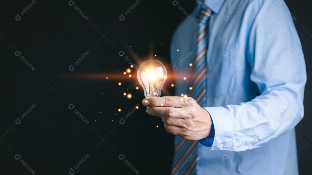 Mão de empresário segurando lâmpada com documento financeiro