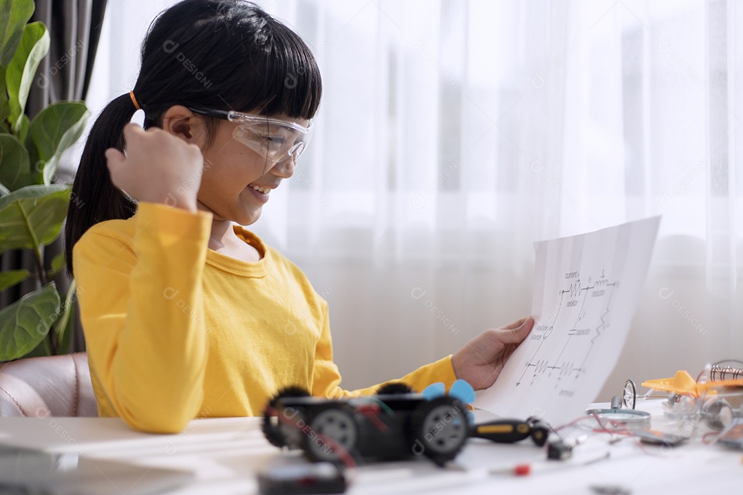Menina asiática aprendendo sistema de carro elétrico.