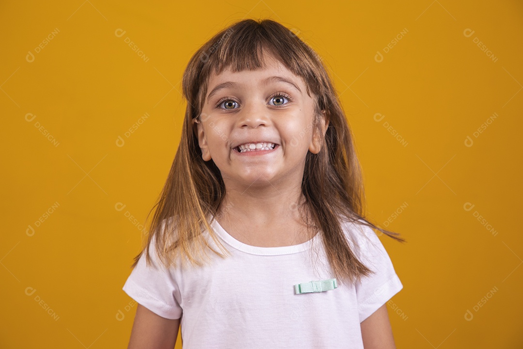 Linda menina criança sorridente sobre fundo amarelo