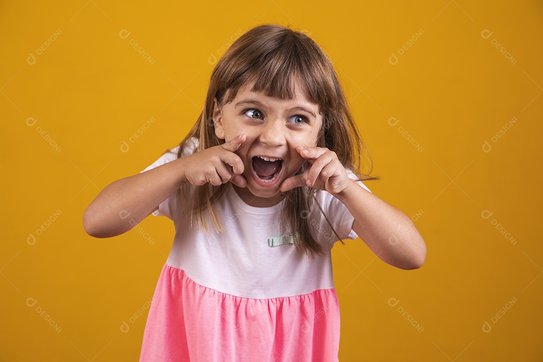 Linda menina criança sorridente sobre fundo amarelo