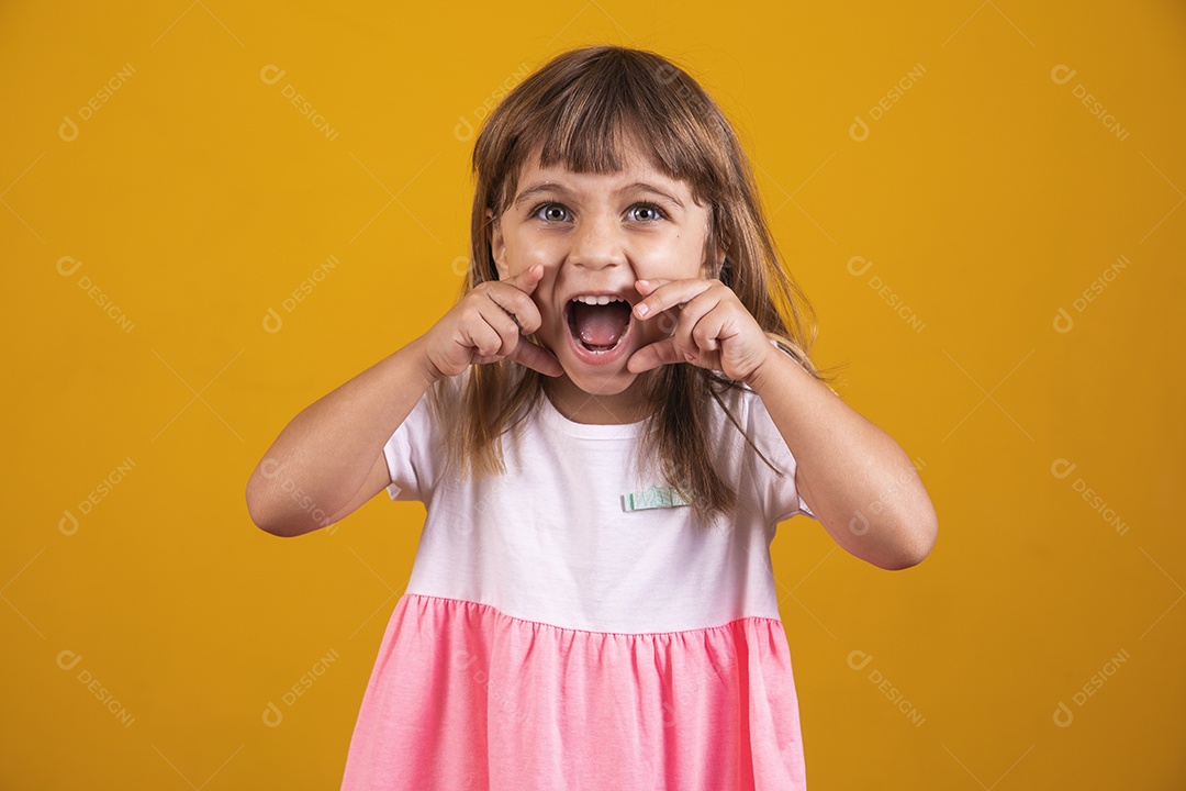 Linda menina criança sorridente sobre fundo amarelo