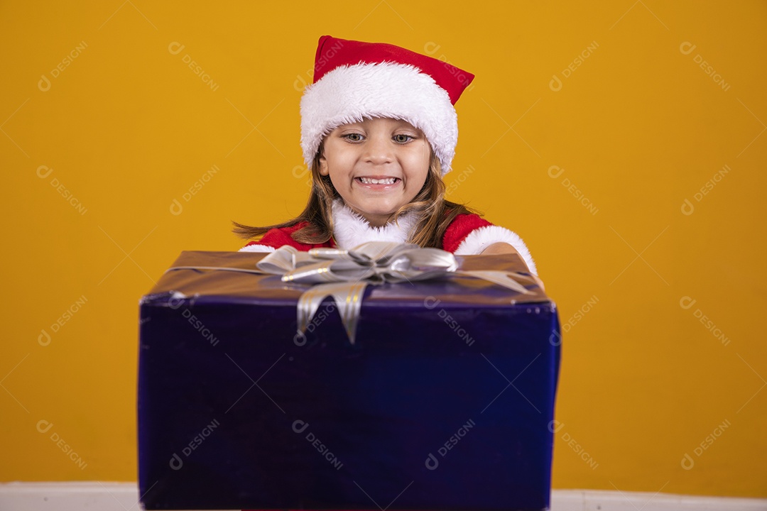 Linda menina criança segurando presentes de natal usando chapéu papai Noel