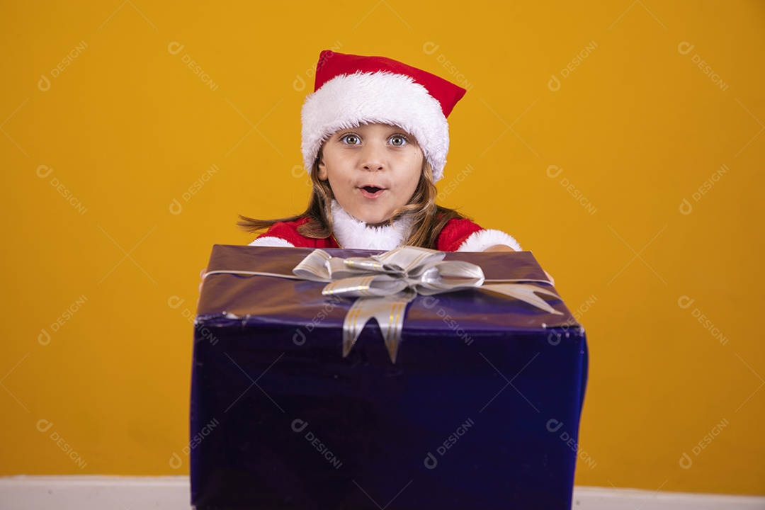 Linda menina criança segurando presentes de natal usando chapéu papai Noel