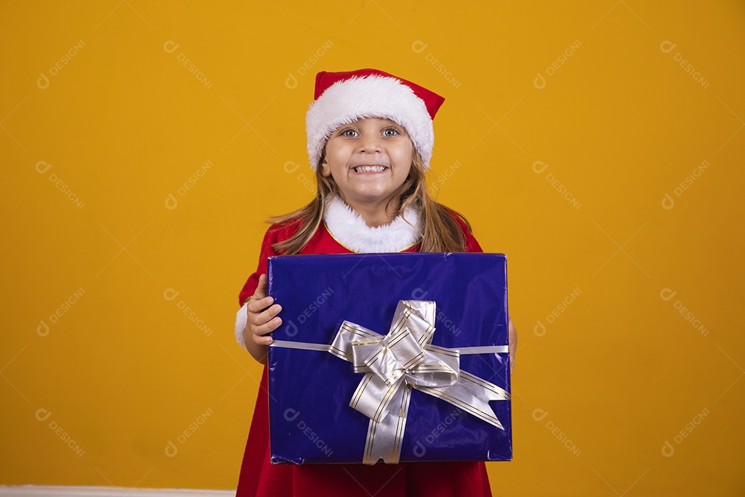 Linda menina criança segurando presentes de natal usando chapéu papai Noel