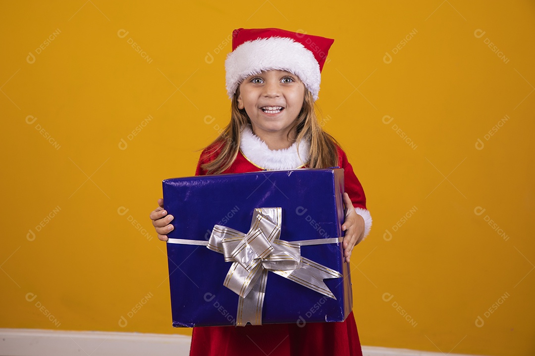 Linda menina criança segurando presentes de natal usando chapéu papai Noel