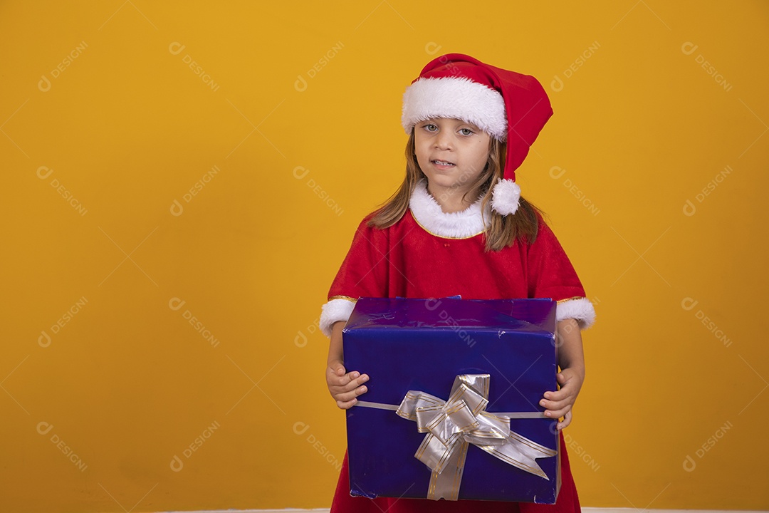 Linda menina criança segurando presentes de natal usando chapéu papai Noel