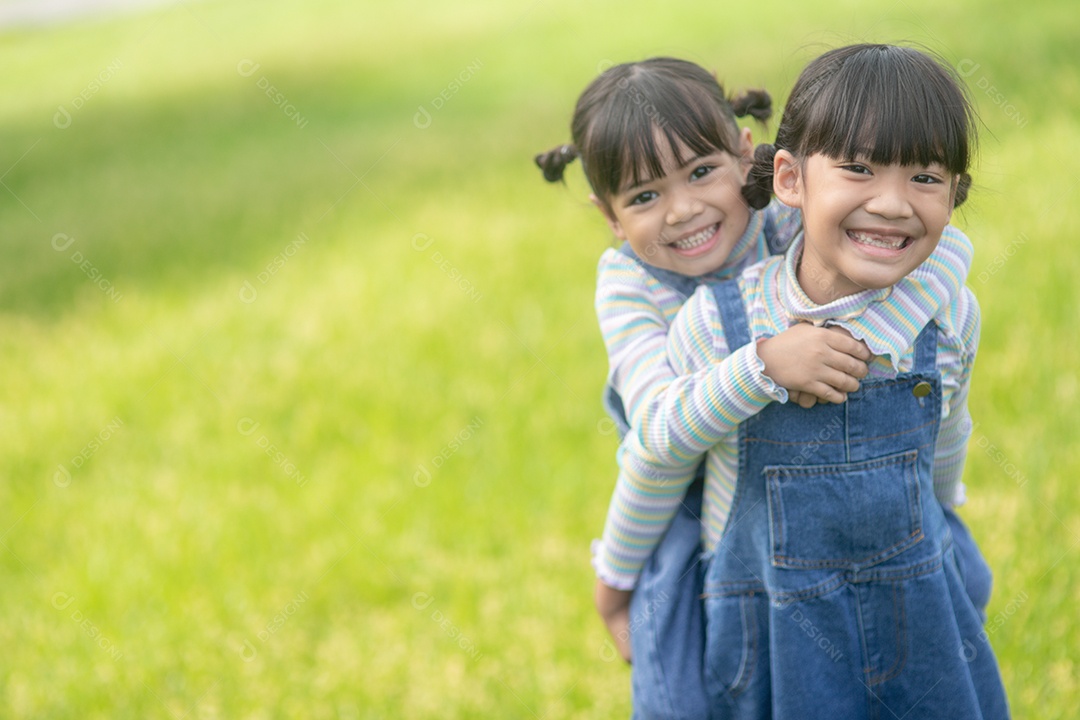 Meninas asiáticas com irmãs mais velha em um parque andando de costas