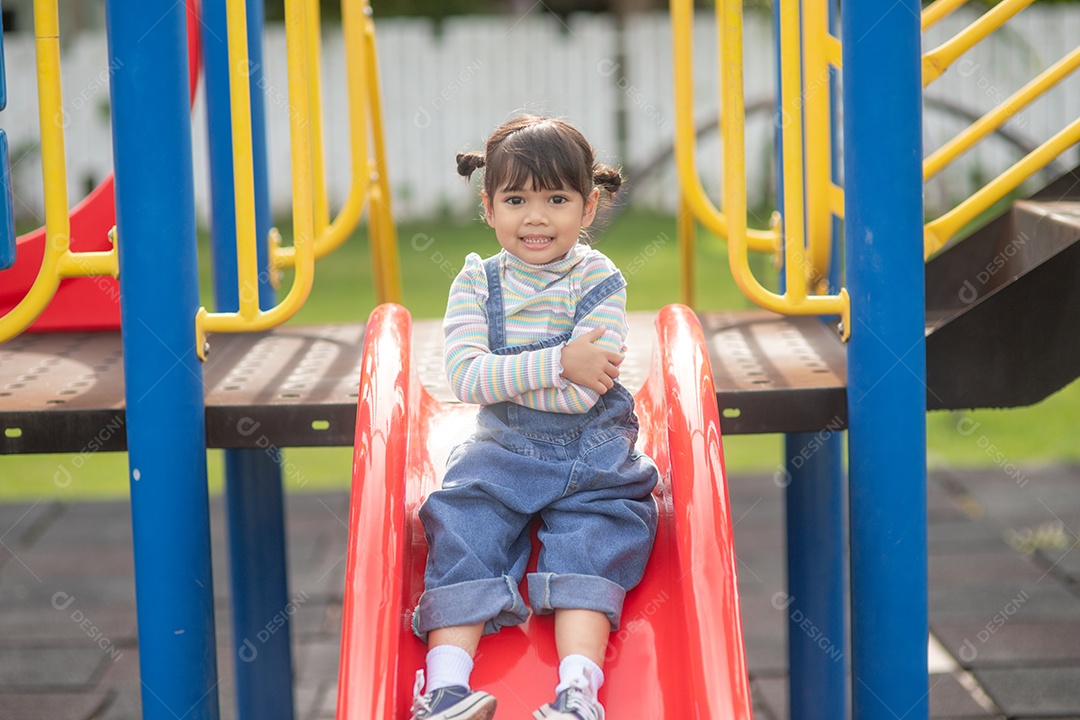 Menina asiática brincando no Parque infantil ao ar livre