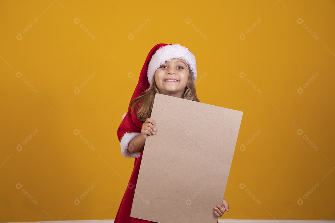 Linda menina criança segurando placa usando chapéu papai Noel feliz natal