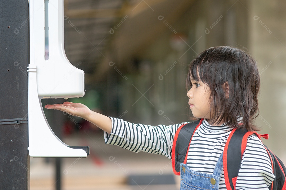 Menina criança usando dispensador automático de gel de álcool pulverizando