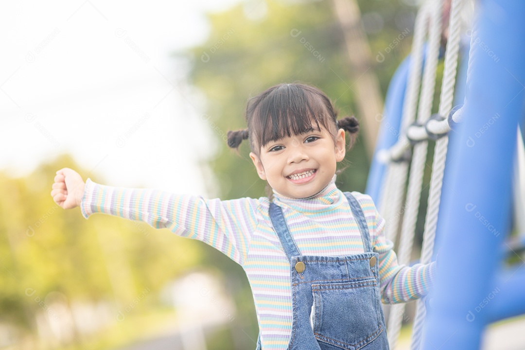 Menina asiática brincando no Parque infantil ao ar livre