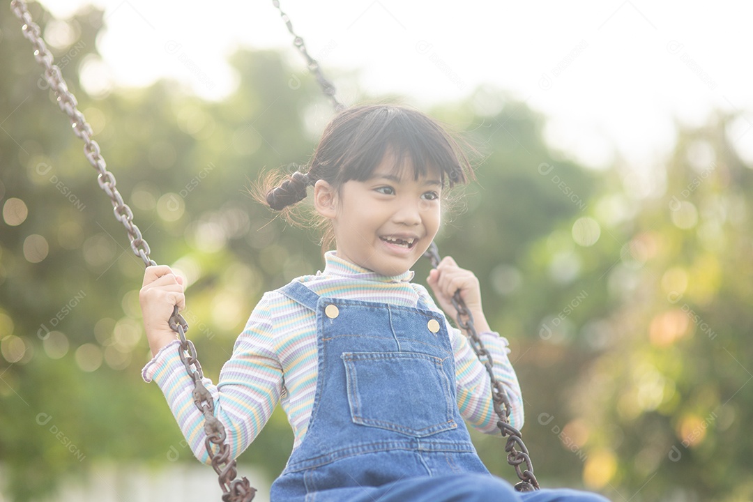 Menina asiática brincando no Parque infantil ao ar livre