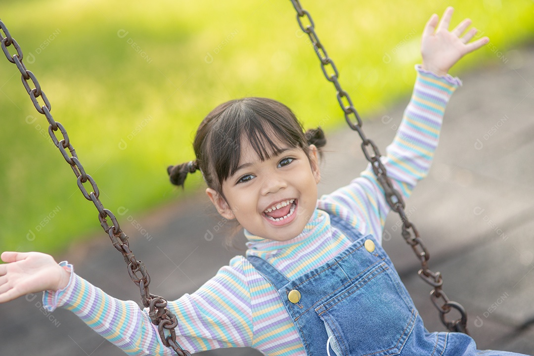 Menina asiática brincando no Parque infantil ao ar livre