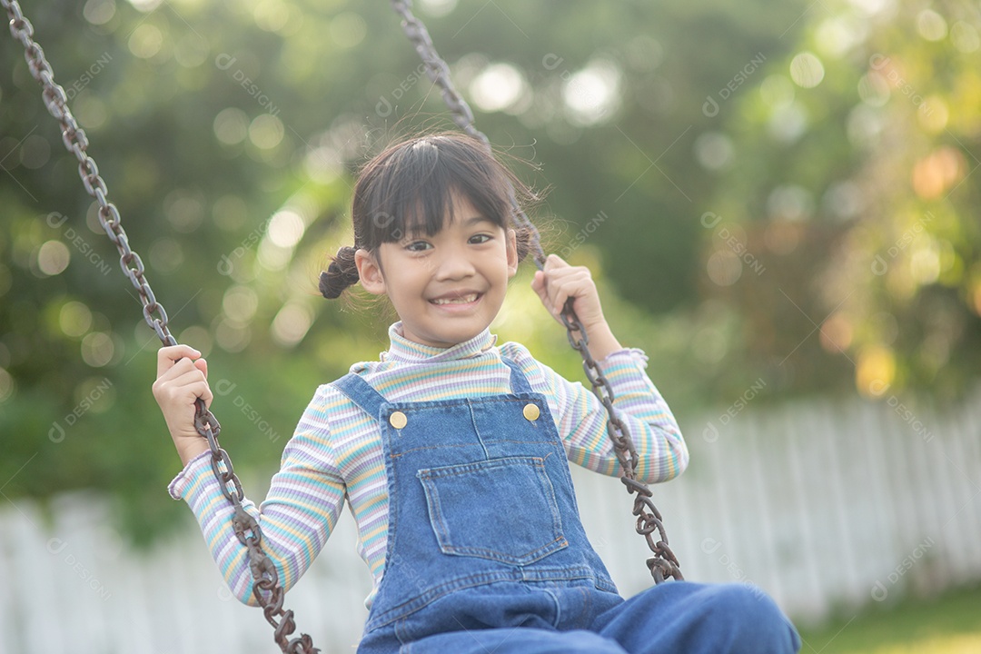 Menina asiática brincando no Parque infantil ao ar livre