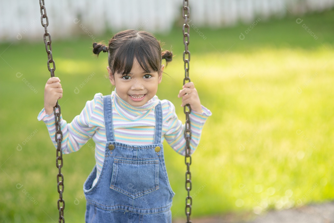 Menina asiática brincando no Parque infantil ao ar livre