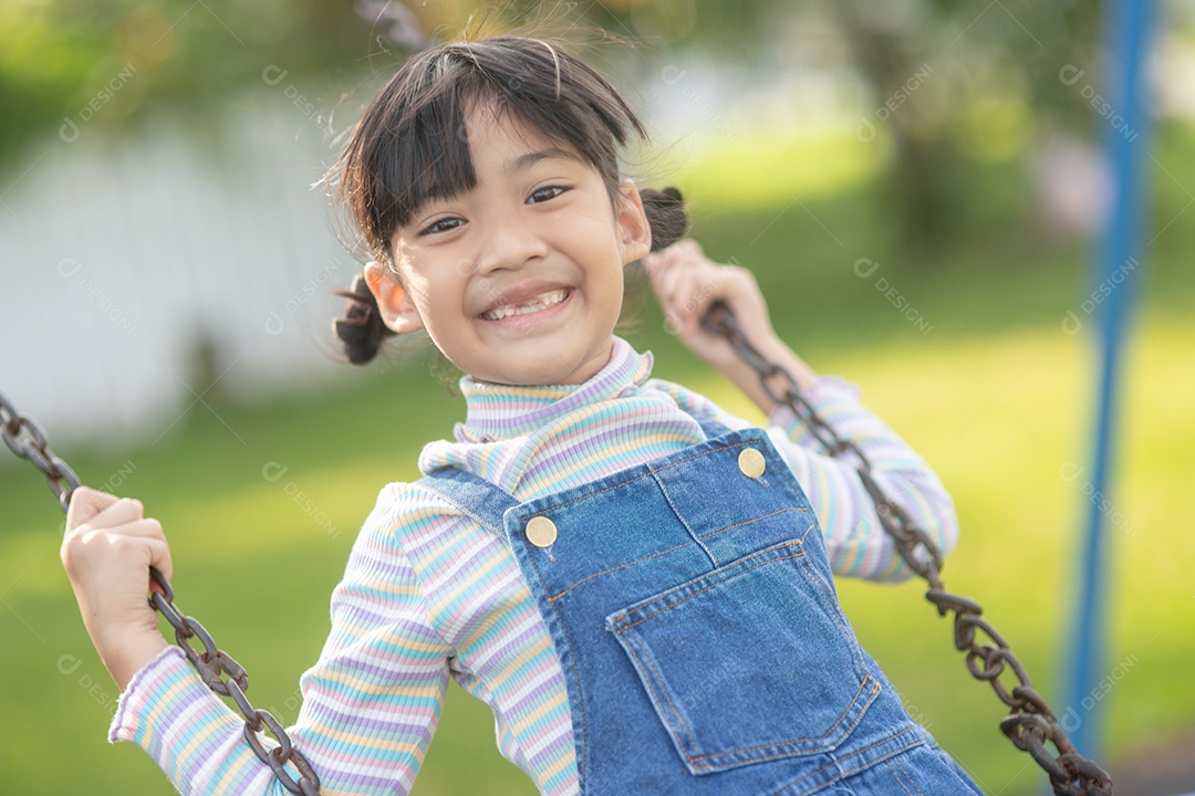 Menina asiática brincando no Parque infantil ao ar livre