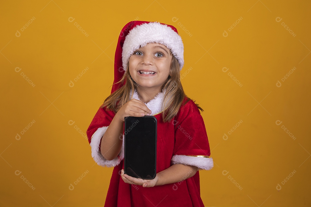 Beautiful child girl holding cell phone wearing santa claus hat merry christmas
