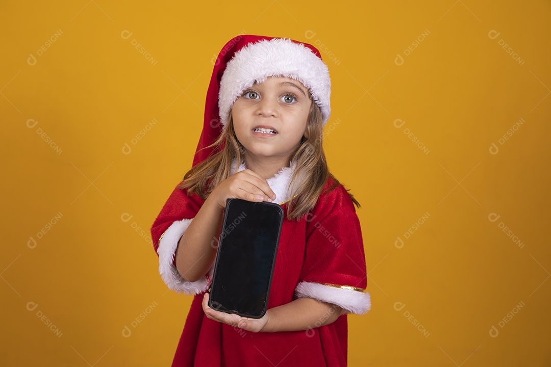 Linda menina criança segurando celular usando chapéu papai Noel feliz natal